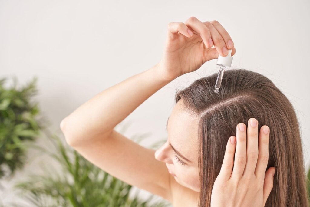 woman applying argan oil to hair