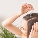 woman applying argan oil to hair